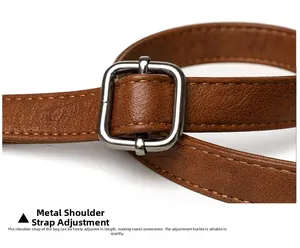 Macro detail of brown leather shoulder strap with silver metal adjustable buckle