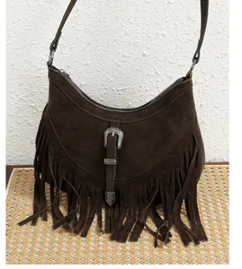 Détail du sac bandoulière en daim marron foncé avec de longues franges et boucle argent