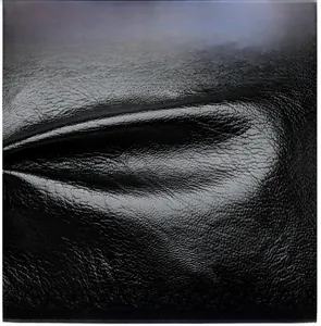 Close-up of black lychee grain faux leather texture on fashionable backpack details