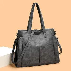 Deep charcoal soft leather tote bag with dual front pockets and adjustable shoulder strap