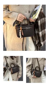 Macro detail of dark coffee checkerboard handbag with bead tassel and buckle accent