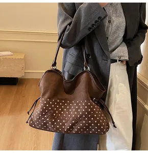 Details von rosa Punkten und Stickereien auf einer braunen Wildleder-Tote-Bag für Damen