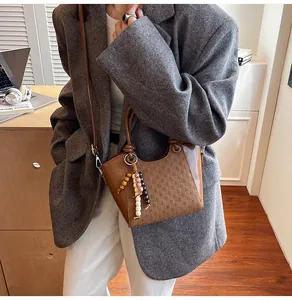 Sac seau en cuir marron avec charme en perles de bois et bandoulière réglable