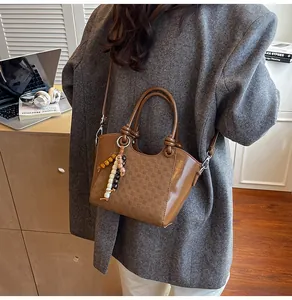 Vue détaillée d'un sac seau marron foncé avec des perles en bois et une bandoulière