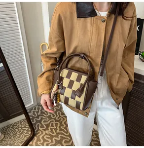 Detailed macro view of woven brown checkerboard texture on minimalist shoulder bag