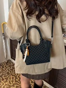 Sac seau noir minimaliste avec coutures en damier et pendentif décoratif en bois