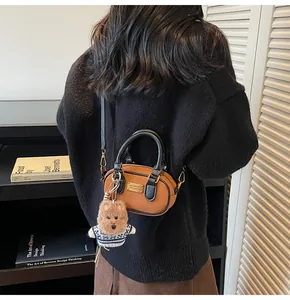 Retro coffee baguette bag with bear charm shown on model in cozy indoor setting