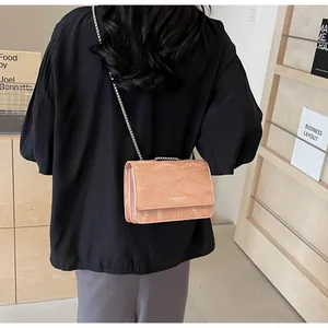 Dettaglio della borsa rosa con trama marmo e catena argentata indossata da modella