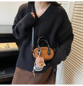 Close-up of retro baguette bag with brown leather and cute teddy bear pendant detail