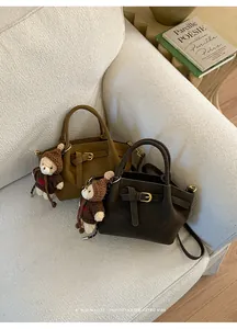 Close-up of retro suede bucket bags with leather buckles and cute bear charms