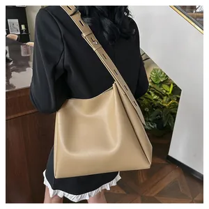 Detail of the khaki tote bag with a wide adjustable shoulder strap on a model
