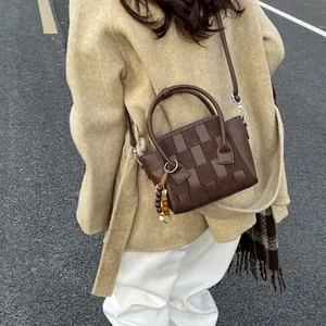 Minimalist woven checkered handbag in dark brown leather with vintage beaded tassel detail