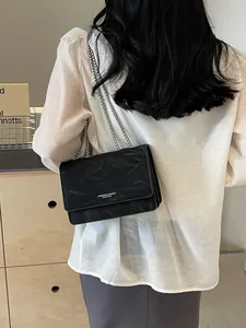 Borsa a tracolla nera in pelle stropicciata con catena argentata e stile moderno