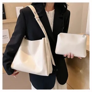 Detail of minimalist cream tote bag set with adjustable strap on a wooden shelf