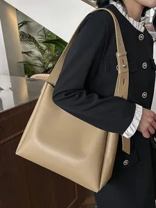 Minimalist khaki leather tote bag with wide adjustable shoulder strap shown on model