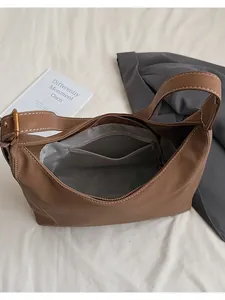 Detail view of brown leather hobo bag with contrast stitching and zipper closure
