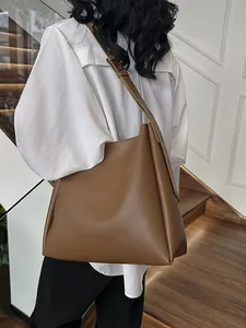 Minimalist caramel brown leather tote bag with adjustable wide strap for women