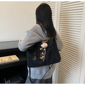 Detalle de un bolso tote vintage negro grande con hebilla dorada y colgante de osito