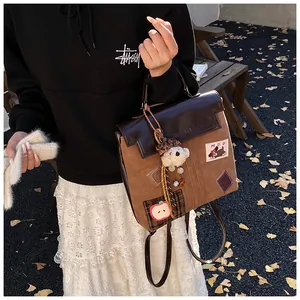 Détail d'un sac cabas vintage en patchwork avec un charm d'ours en peluche mignon