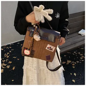 Détail du sac rétro patchwork marron avec broderie chien et pendentif en peluche