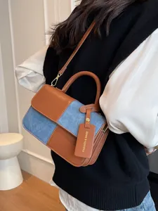 Bolso baguette retro de cuero marrón y patchwork de mezclilla azul con herrajes dorados