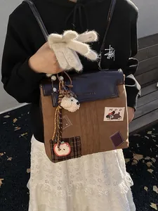Sac à dos en cuir marron style vintage college avec écussons mignons sur un banc en bois