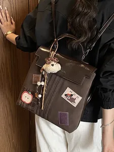 Sac à dos patchwork marron foncé avec écussons décoratifs et breloque chien