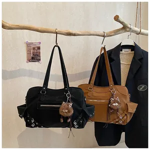 Detail of canvas tote bags with front zipper, metal buckles, and plush monster pendant