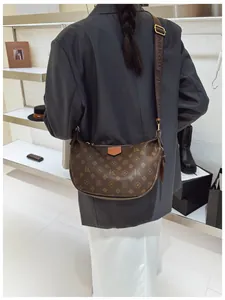 Detailed back view of a brown monogram crescent bag with wide logo fabric strap