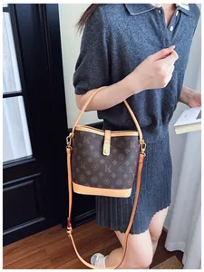 Detail of vintage printed bucket bag with gold lock shown in a lifestyle setting