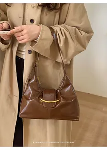 Sac hobo en cuir poli marron avec une boucle décorative en métal doré incurvé sur le devant