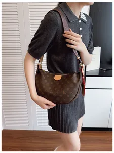 Detail of hobo bag featuring monogram print and adjustable brown wide strap