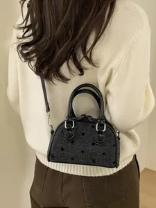 Minimalist bag with polka dot texture and leather handles shown on model back