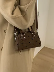 Chic brown polka dot baguette bag with leather handles and adjustable shoulder strap