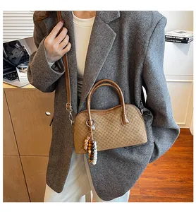 Sac baguette à carreaux marron avec charme en perles présenté dans un cadre de vie décontracté