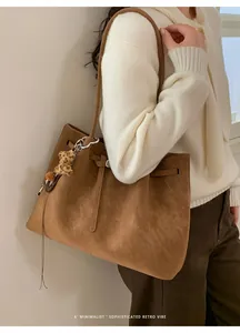 Detail of retro brown tote bag with leopard plush charm and vintage matte finish texture