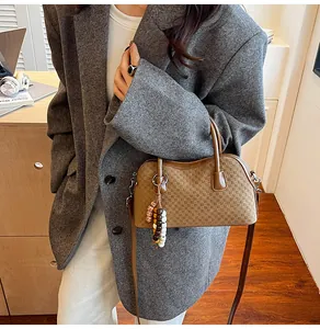 Brown baguette bag with checkered embossing and colorful bead tassel on office desk