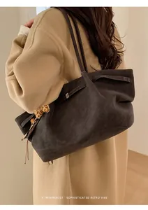 Bolso tote gris carbón minimalista con colgante de leopardo y abrigo de lana beige