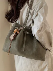Large olive green suede tote bag with decorative leopard charm and long shoulder straps