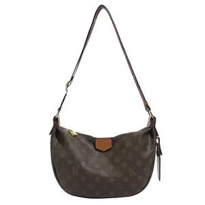 Brown monogram dumpling bag with caramel leather trim and gold zipper detail