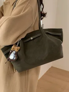 Bolso tote minimalista en ante verde oliva con un amuleto de corazón con estampado leopardo