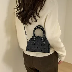 Miniature black Boston bag with polka dot embroidery and silver hardware in a crossbody style