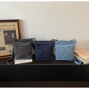 Trois sacs seaux en denim présentés en gris, bleu foncé et bleu clair élégants