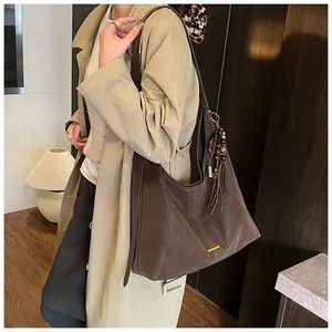 Dettaglio della borsa tote in pelle marrone scuro con nappa vintage e inserti in metallo