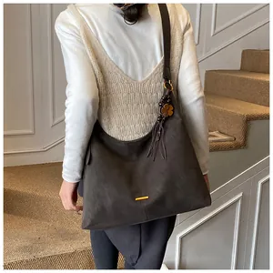 Detail van de donkerbruine matte shopper met gouden hardware en kwastjes decoratie