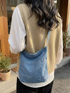 Sac seau chic en toile de denim avec poches superposées porté par un mannequin dehors