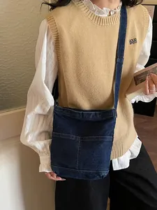 Sac seau en denim bleu foncé minimaliste porté par un mannequin dans un décor élégant
