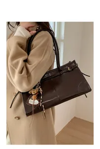 Vue détaillée du sac cabas vintage en cuir marron avec miroir cœur et breloque léopard