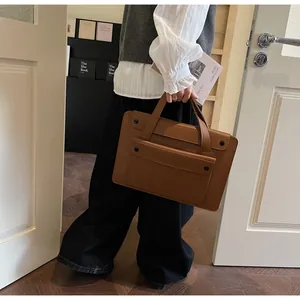 Close-up of vintage brown tote bag featuring outer pocket and durable double handles