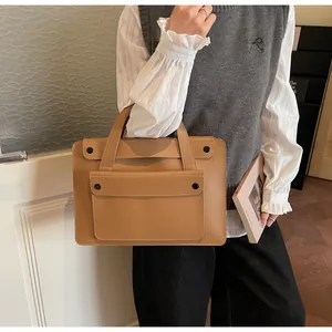 Detail of khaki leather tote with reinforced handles and large front flap pocket